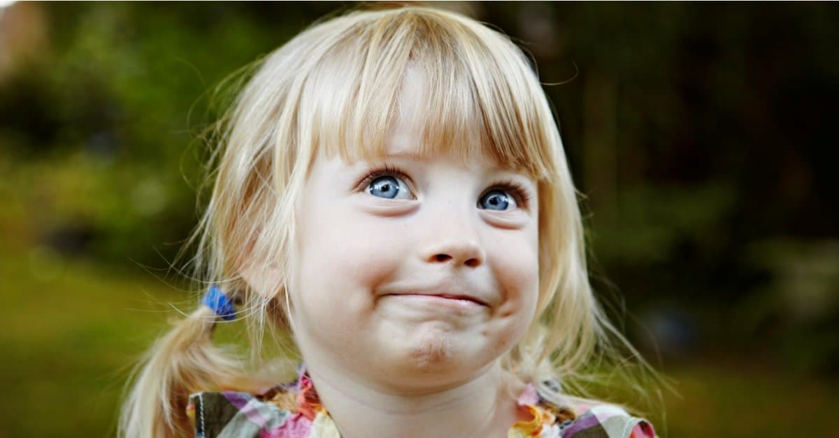 Young girl in backyard smiling looking up