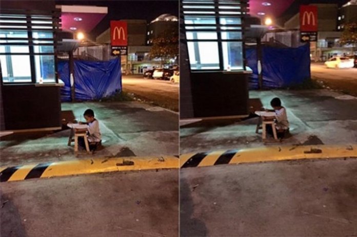 A foto que emocionou o mundo: menino, morador de rua, se vale da luz do McDonald’s para fazer lição de casa