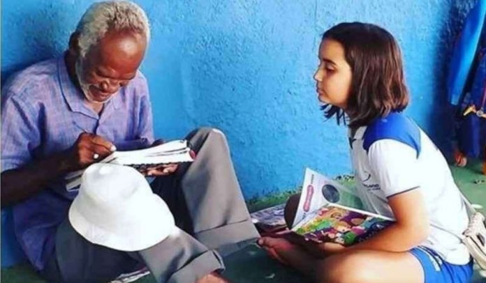 Cena linda: Estudante alfabetiza vendedor de picolé da escola